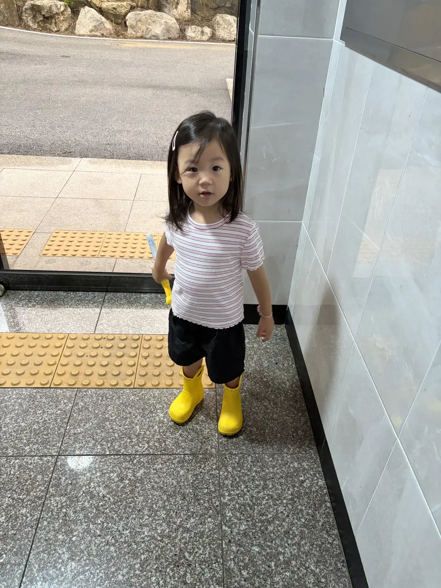 노란색 크록스 유아장화를 신은 아이의 비 오는 날 코디
